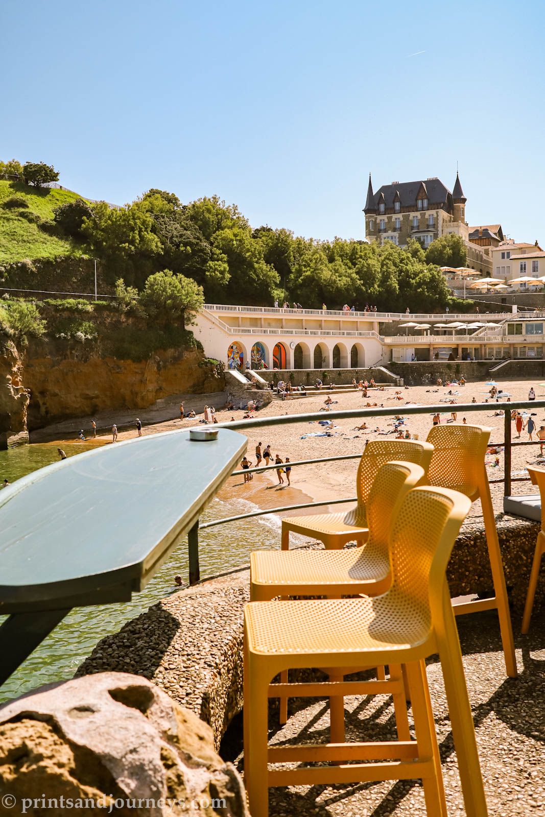 View of plage du port vieux with yellow bar chairs in front on a sunny day