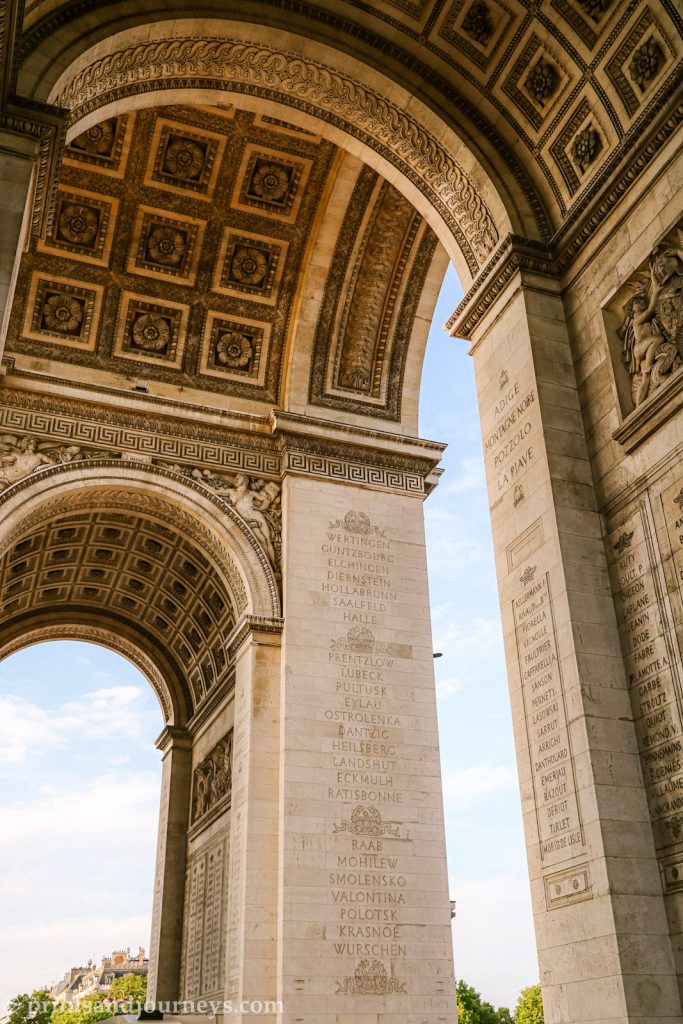 the arc de triomphe archways with blue skies in between.