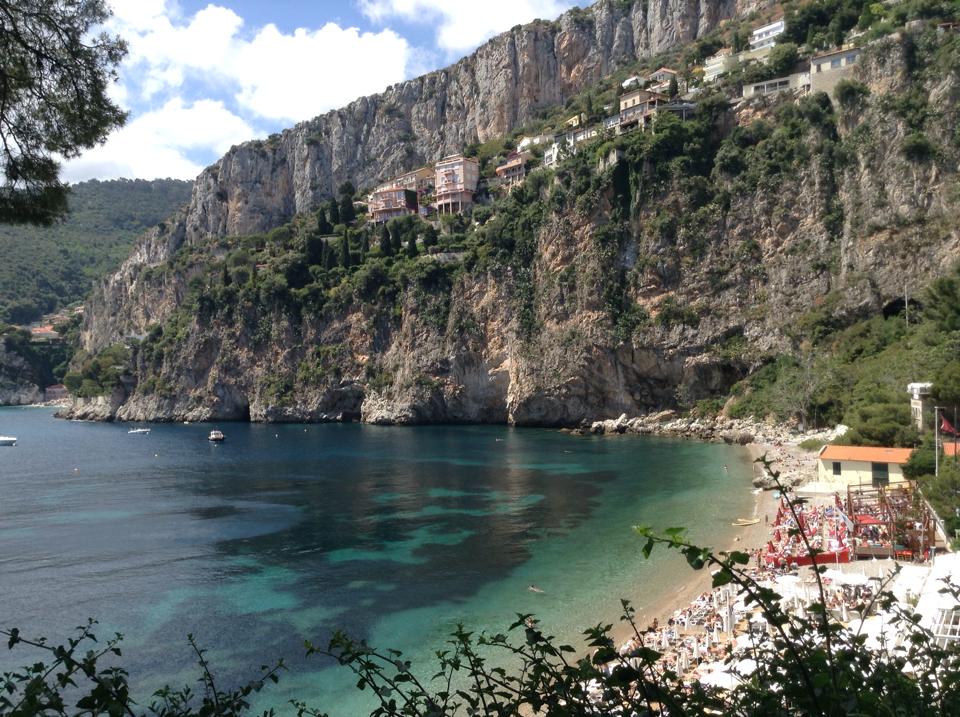 mala beach on the french riviera seen from above with dramatic cliffs lining the clear ocean and beach
