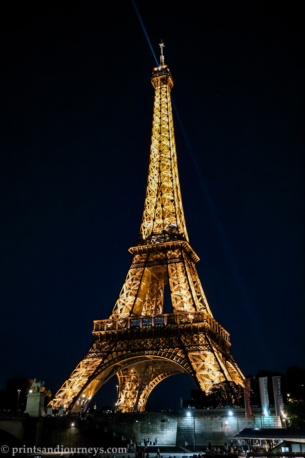 the lit up eiffel tower at night in full from a distance
